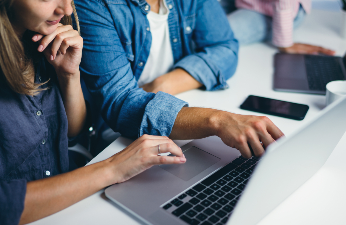 Två personer sitter vid en laptop